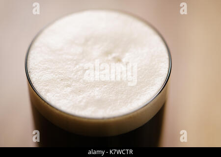 Dunkle Bier im Glas auf Holz Tabelle gegossen Stockfoto