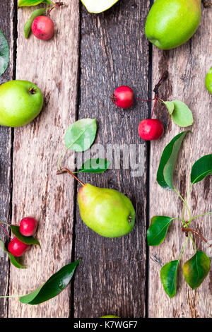 Birne und kleinen Apple auf Holz rustikale Hintergrund. Ansicht von oben. Rahmen. Herbst Ernte Stockfoto