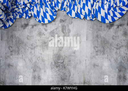 Zerknitterte Fahne mit bayerischen Farben Weiß und Blau auf leere Betonwand Stockfoto