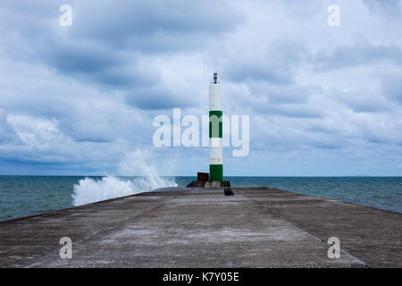 Starke Winde am Hafen Leuchtturm auf dem steinernen Steg in Aberystwyth Ceredigion Mid Wales UK Stockfoto