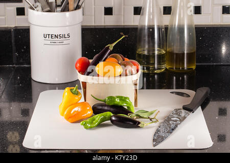 Frisch geerntete Tomaten, Sweet orange und grüne Paprika und Auberginen. Auf Zähler nach oben an Bord genommen. Stockfoto