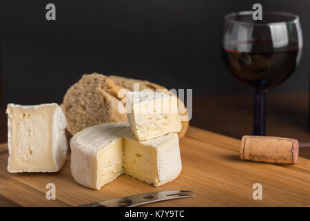 Auswahl an Käse auf einem Holzbrett mit Wein Stockfoto