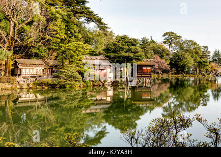 Kanazawa, Kenrokuen Garten, einer der Top drei Gärten in Japan. Kasumigaike, Kasumi Teich, mit Tee Zimmer entlang der Bank. Goldene Stunde. Stockfoto