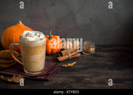 Pumpkin Spice Latte. Tasse Latte mit saisonalen Herbst Gewürze, Kekse und Fall Dekor. Traditionelle Kaffee Trinken für die Herbstferien. Stockfoto