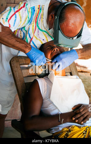 Freiwillige italienische Zahnarzt bei der Arbeit mit lokalen madagassischen Patienten auf seinem Hotel bungalow Veranda, ambatoloaka Strand, Nosy Be Madagaskar Stockfoto