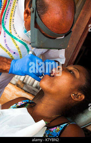 Freiwillige italienische Zahnarzt bei der Arbeit mit lokalen madagassischen Patienten auf seinem Hotel bungalow Veranda, ambatoloaka Strand, Nosy Be Madagaskar Stockfoto