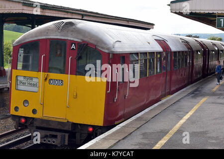 Eine Insel Linie Hauptbahn Zug auf der Isle of Wight in Großbritannien mit einem alten Bakerloo Line U-Bahn am Brading station Heritage Railway Museum. Stockfoto