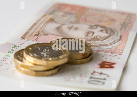 Bild des Neuen, Kunststoff, zehn Pfund Sterling, mit fünf Pfund Sterling Münzen auf seine Spitze. Stockfoto