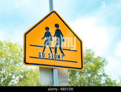 Schule crossing Schild mit blauem Himmel und gehen Sie langsam Schriftzug Stockfoto