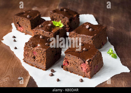 Dark chocolate Brownies mit mint Blatt auf hölzernen Tisch dekoriert. Detailansicht horizontale Zusammensetzung Stockfoto