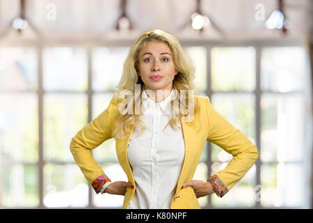 Ernsthafte junge Geschäftsfrau, die Hände auf den Hüften. Stockfoto