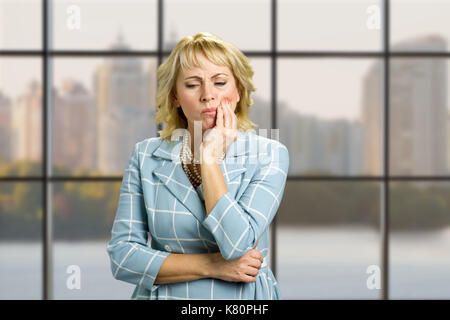 Unglücklich, reife Frau leiden Zahnschmerzen. Stockfoto