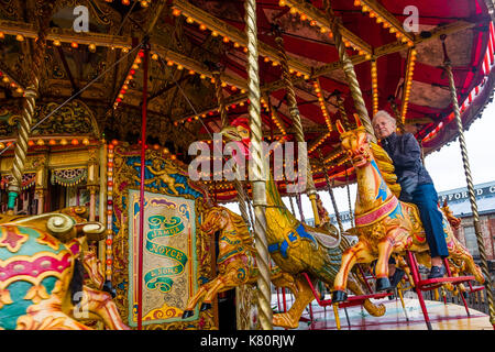 Aberystwyth Wales UK, Sonntag, den 17. September 2017 eine Frau genießen Sie eine Fahrt mit der Noyce & Söhne berühmter verzierten goldenen Gallopers' Karussell Blümchen an einem Wochenende mit Veranstaltungen zu 95 Jahre des Großen Western auf das Tal von rheidol Schmalspurbahn in Aberystwyth Foto © Keith Morris/Alamy Leben Nachrichten feiern Stockfoto