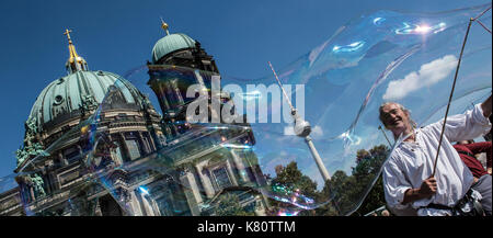 Berlin, Deutschland. 17 Sep, 2017. Street artist Detlev Balser macht große Seifenblasen vor dem Dom und den Fernsehturm in Berlin, Deutschland, 17. September 2017. Foto: Paul Zinken/dpa/Alamy leben Nachrichten Stockfoto