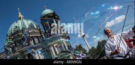 Berlin, Deutschland. 17 Sep, 2017. dpatop - Street artist Detlev Balser macht große Seifenblasen vor dem Dom und den Fernsehturm in Berlin, Deutschland, 17. September 2017. Foto: Paul Zinken/dpa/Alamy leben Nachrichten Stockfoto