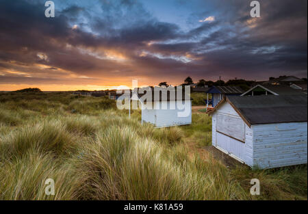 Umkleidekabinen am Strand einen grasbewachsenen Dünen im Old Hunstanton. Stockfoto