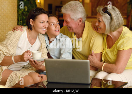 Familie in der Nähe von Tabelle mit Laptop Stockfoto