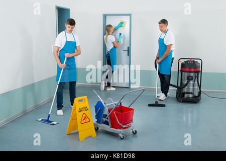 Gruppe von Hausmeister Reinigung Korridor mit Reinigung Ausrüstungen Stockfoto