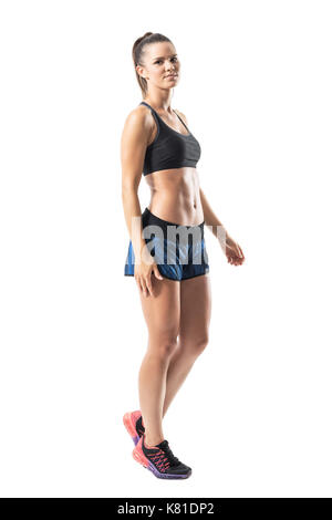 Seitenansicht des entspannten jungen fitness Frau Wandern und Suchen an der Kamera. Voller Körper Länge Porträt auf weißem studio Hintergrund isoliert. Stockfoto