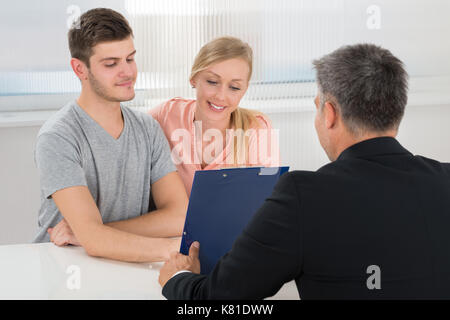 Ansicht der Rückseite des Reifen Geschäftsmann, die Zwischenablage zu Junges Paar Stockfoto