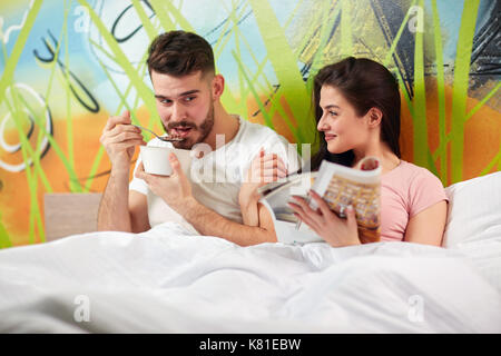 Junge Paare haben angenehmen Morgen im Bett zusammen Stockfoto