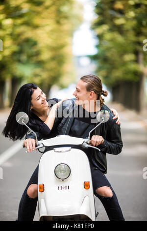 Glückliche Freiheit Paar fahren Roller auf Sommerferien Ferienhäuser aufgeregt. Paar Ride Roller und jedes andere Aussehen Stockfoto