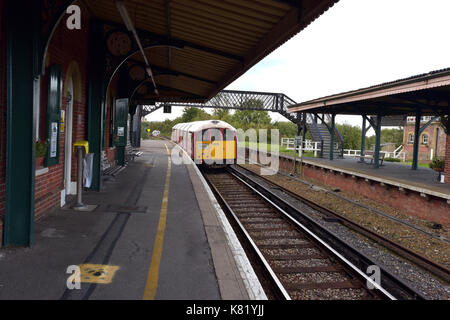 Eine Insel Linie Hauptbahn Zug auf der Isle of Wight in Großbritannien mit einem alten Bakerloo Line U-Bahn am Brading station Heritage Railway Museum. Stockfoto