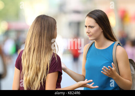 Zwei verärgerte Freunde in einem ernsten Gespräch draußen auf der Straße Stockfoto
