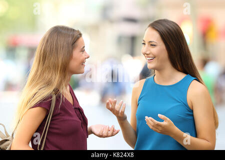 Zwei glückliche Freunde treffen und reden auf der Straße Stockfoto