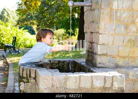 Happy Boy Waschen der Hände in einem Park Stockfoto