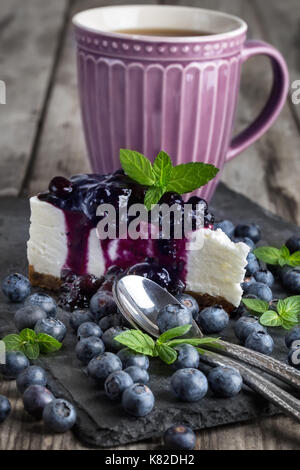 Stück hausgemachten Käsekuchen mit Heidelbeeren Marmelade und frischen Reifen Blaubeeren Stockfoto
