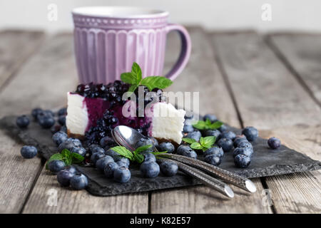 Stück hausgemachten Käsekuchen mit Heidelbeeren Marmelade und frischen Reifen Blaubeeren Stockfoto