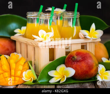 Frische mango Saft in kleinen Flaschen in Holzkiste Stockfoto