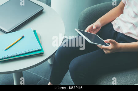 Nahaufnahme der Hand des Mädchens sitzen und leerer Bildschirm berühren von Tablet Computer mit Notizbuch und Bleistift auf Tisch in Campus, On-line-Ausbildung (e-learning) Konz Stockfoto