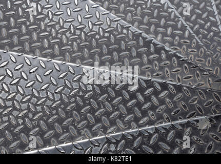 Schwarz lackiert industrielle Anti geprägtem Metall Stahl Platte Stufen der Treppe mit diagonal Stöße von rautenmuster Textur, Hintergrund, Nahaufnahme Stockfoto