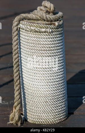 Nautische Seil in der Spirale aufgewickelt auf Liegeplatz Pol. Stockfoto