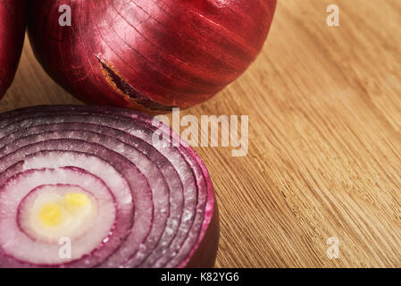 Halbe rote Zwiebel auf einem hölzernen Hintergrund Stockfoto