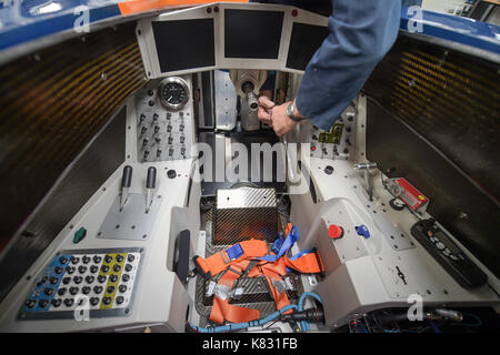 Ein Ingenieur zieht die Schrauben im Cockpit nach dem Einbau eine Fußplatte auf die BLOODHOUND SSC an der Bloodhound Technical Center in Avonmouth, wie das Auto ist für die Prüfung in Newquay im Oktober vorbereitet. Stockfoto