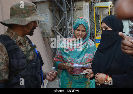 Lahore, Pakistan. 18 Sep, 2017. Sicherheit Personal stand guard Warteschlange als Wähler ihre Stimmzettel in NA zu werfen - 120 durch die Wahl. Wahl begann um 8 Uhr in 220 Wahllokalen in die Landeshauptstadt. Insgesamt 44 Kandidaten wetteifern für die Nationalversammlung Sitz von Lahore. Credit: Rana Sajid Hussain/Pacific Press/Alamy leben Nachrichten Stockfoto