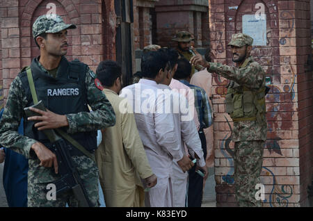 Lahore, Pakistan. 18 Sep, 2017. Sicherheit Personal stand guard Warteschlange als Wähler ihre Stimmzettel in NA zu werfen - 120 durch die Wahl. Wahl begann um 8 Uhr in 220 Wahllokalen in die Landeshauptstadt. Insgesamt 44 Kandidaten wetteifern für die Nationalversammlung Sitz von Lahore. Credit: Rana Sajid Hussain/Pacific Press/Alamy leben Nachrichten Stockfoto