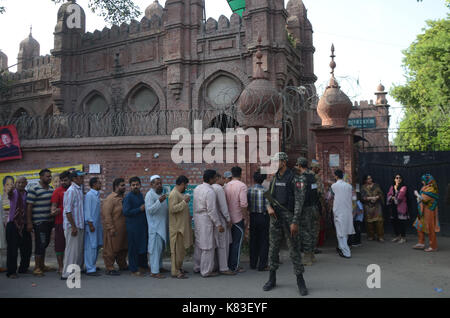 Lahore, Pakistan. 18 Sep, 2017. Sicherheit Personal stand guard Warteschlange als Wähler ihre Stimmzettel in NA zu werfen - 120 durch die Wahl. Wahl begann um 8 Uhr in 220 Wahllokalen in die Landeshauptstadt. Insgesamt 44 Kandidaten wetteifern für die Nationalversammlung Sitz von Lahore. Credit: Rana Sajid Hussain/Pacific Press/Alamy leben Nachrichten Stockfoto