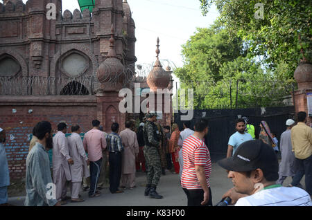 Lahore, Pakistan. 18 Sep, 2017. Sicherheit Personal stand guard Warteschlange als Wähler ihre Stimmzettel in NA zu werfen - 120 durch die Wahl. Wahl begann um 8 Uhr in 220 Wahllokalen in die Landeshauptstadt. Insgesamt 44 Kandidaten wetteifern für die Nationalversammlung Sitz von Lahore. Credit: Rana Sajid Hussain/Pacific Press/Alamy leben Nachrichten Stockfoto