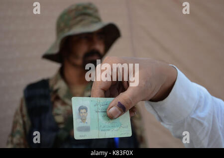 Lahore, Pakistan. 18 Sep, 2017. Sicherheit Personal stand guard Warteschlange als Wähler ihre Stimmzettel in NA zu werfen - 120 durch die Wahl. Wahl begann um 8 Uhr in 220 Wahllokalen in die Landeshauptstadt. Insgesamt 44 Kandidaten wetteifern für die Nationalversammlung Sitz von Lahore. Credit: Rana Sajid Hussain/Pacific Press/Alamy leben Nachrichten Stockfoto