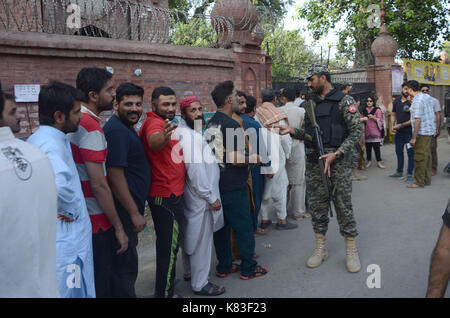 Lahore, Pakistan. 18 Sep, 2017. Sicherheit Personal stand guard Warteschlange als Wähler ihre Stimmzettel in NA zu werfen - 120 durch die Wahl. Wahl begann um 8 Uhr in 220 Wahllokalen in die Landeshauptstadt. Insgesamt 44 Kandidaten wetteifern für die Nationalversammlung Sitz von Lahore. Credit: Rana Sajid Hussain/Pacific Press/Alamy leben Nachrichten Stockfoto