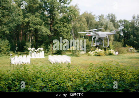 Videografie Hochzeit aus der Luft eine kleine Spion quad Copter scout Drohne durch die Bäume in den Wald fliegen. Stockfoto