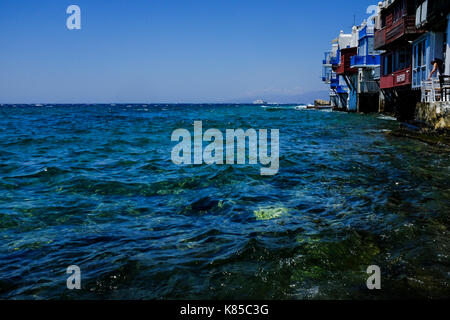 Allgemeine Blick auf die Waterfront, Gebäuden und Menschen angeln in Mykonos, Griechenland im Juli 2016. Auch Möwen warten auf einen Geschmack von Fisch. Stockfoto