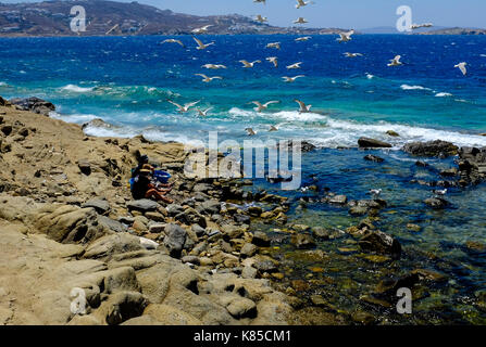 Allgemeine Blick auf die Waterfront, Gebäuden und Menschen angeln in Mykonos, Griechenland im Juli 2016. Auch Möwen warten auf einen Geschmack von Fisch. Stockfoto