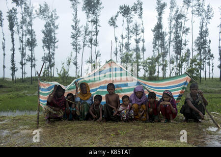 September 17, 2017 - septembar 17, 2017, Cox's Bazar, Bangladesch - Rohingya Familie deckt mit Kunststoff für Regen in den Straßen, wie sie für Abwechslung bei Shaplapur, Cox's Bazar, Bangladesch warten. Laut UNHCR mehr als 400 tausend Rohingya-flüchtlinge Myanmar haben von Gewalt flohen in den letzten Wochen, die meisten versuchen, die Grenze zu überqueren und Bangladesch zu erreichen. Internationale Organisationen haben Nachmeldungen von Menschenrechtsverletzungen und Exekutionen angeblich durchgeführt von der myanmarischen Armee. Credit: K M Asad/ZUMA Draht/Alamy leben Nachrichten Stockfoto