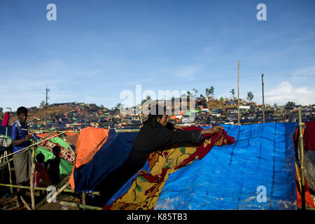 September 17, 2017 - septembar 17, 2017, Cox's Bazar, Bangladesch - Rohingya Frauen halten Kleidung in der Sonne an Thenkhali Flüchtlingslager in Cox's Bazar, Bangladesch zu trocknen. Laut UNHCR mehr als 400 tausend Rohingya-flüchtlinge Myanmar haben von Gewalt flohen in den letzten Wochen, die meisten versuchen, die Grenze zu überqueren und Bangladesch zu erreichen. Internationale Organisationen haben Rep atorted Ansprüche von Menschenrechtsverletzungen und Exekutionen angeblich durchgeführt von der myanmarischen Armee. Credit: K M Asad/ZUMA Draht/Alamy leben Nachrichten Stockfoto