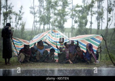 September 17, 2017 - septembar 17, 2017, Cox's Bazar, Bangladesch - Rohingya Familie deckt mit Kunststoff für Regen in den Straßen, wie sie für Abwechslung bei Shaplapur, Cox's Bazar, Bangladesch warten. Laut UNHCR mehr als 400 tausend Rohingya-flüchtlinge Myanmar haben von Gewalt flohen in den letzten Wochen, die meisten versuchen, die Grenze zu überqueren und Bangladesch zu erreichen. Internationale Organisationen haben Nachmeldungen von Menschenrechtsverletzungen und Exekutionen angeblich durchgeführt von der myanmarischen Armee. Credit: K M Asad/ZUMA Draht/Alamy leben Nachrichten Stockfoto